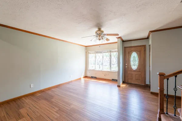 a view of a livingroom with a furniture wooden floor and staircase