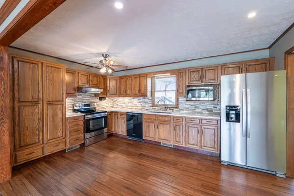 a kitchen with stainless steel appliances a refrigerator and a wooden floors