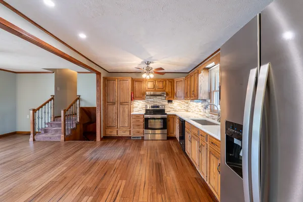 a kitchen with stainless steel appliances granite countertop a sink a stove a microwave and cabinets
