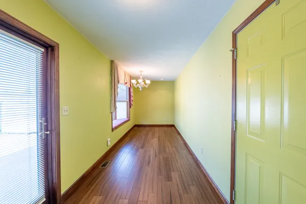 a view of a hallway with wooden floor and staircase
