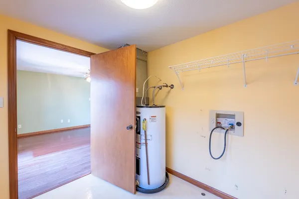 an empty room with wooden floor closet and windows