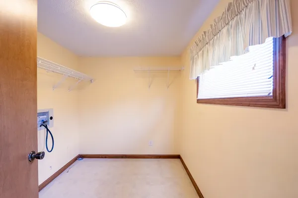a view of an empty room and window and wooden floor