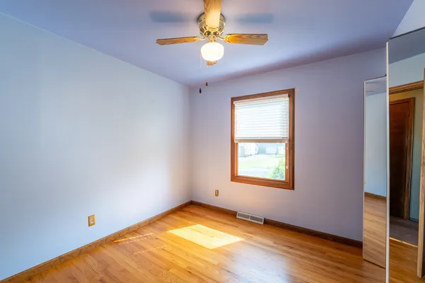 a view of a big room with windows and chandelier fan