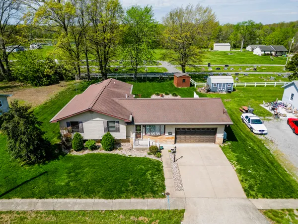 a aerial view of a house with a yard table and chairs