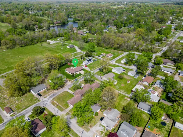 an aerial view of residential houses with outdoor space and trees
