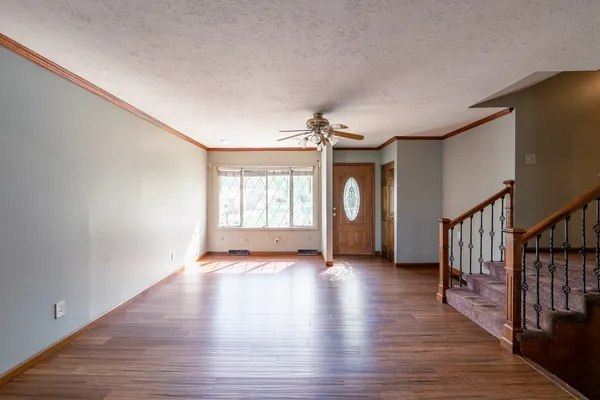 a view of an empty room with window and wooden floor