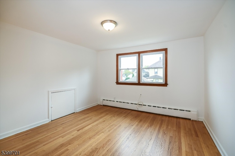 13 Knapp Avenue Clifton, NJ 07011 - Photo 11 of 17 an empty room with wooden floor and windows