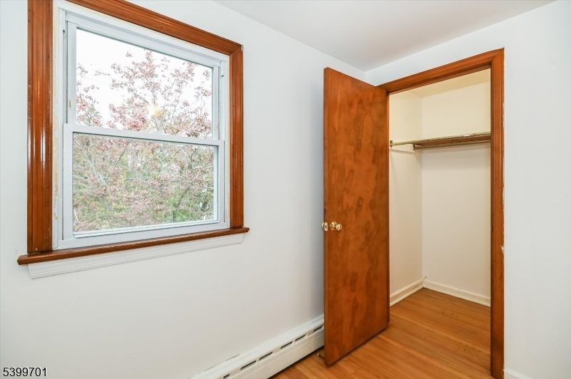 13 Knapp Avenue Clifton, NJ 07011 - Photo 16 of 17 an empty room with wooden floor and a window