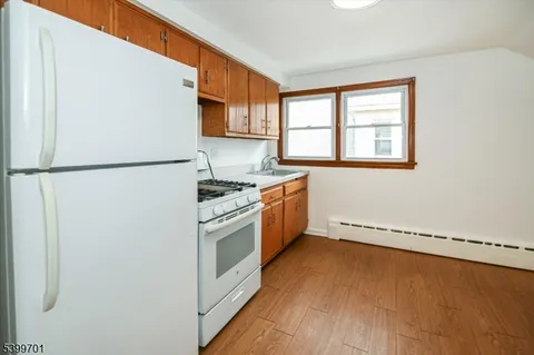 a kitchen with a refrigerator a stove a sink and a window
