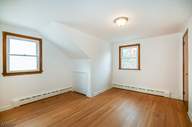 13 Knapp Avenue Clifton, NJ 07011 - Photo 10 of 17 an empty room with wooden floor and windows
