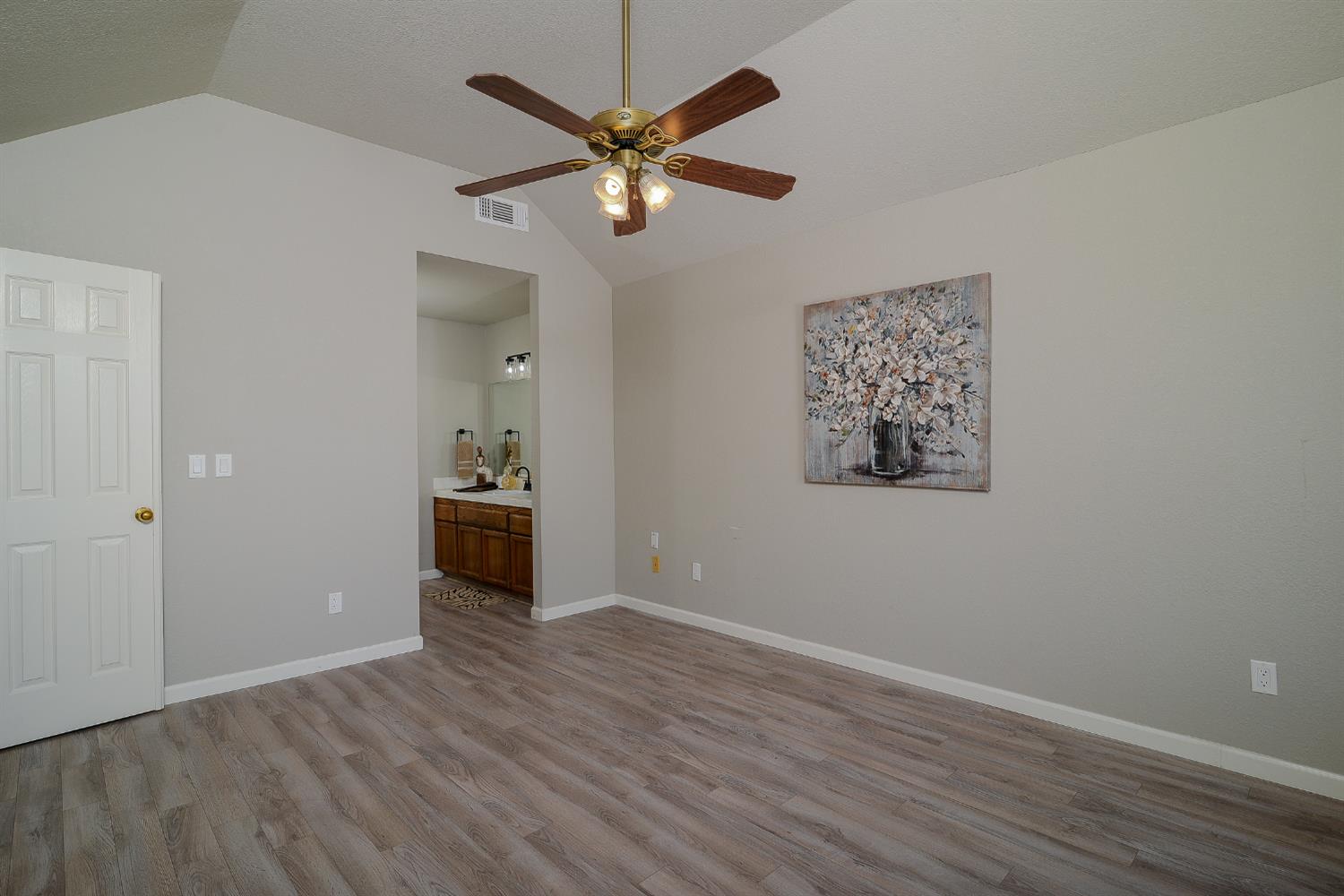 4055 Alex Lane Carmichael, CA 95608 - Photo 17 of 47 an empty room with wooden floor chandelier fan and windows