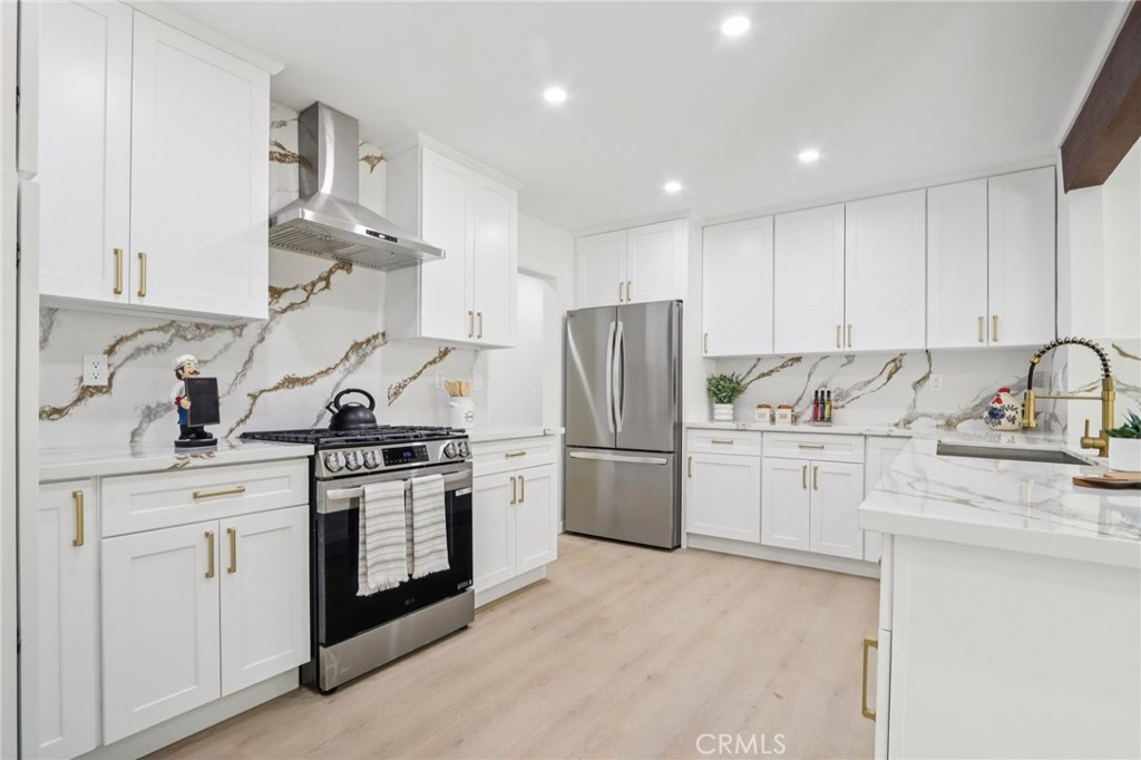 11060 Vanda Way Sun Valley, CA 91352 - Photo 10 of 43 a kitchen with stainless steel appliances granite countertop a sink a stove a refrigerator and white cabinets