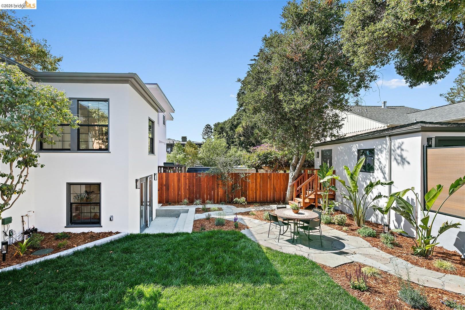 1668 Arch Street Berkeley, CA 94709 - Photo 51 of 78 Manicured lawn with a stone pathway, leading to a patio area with a round table and seating