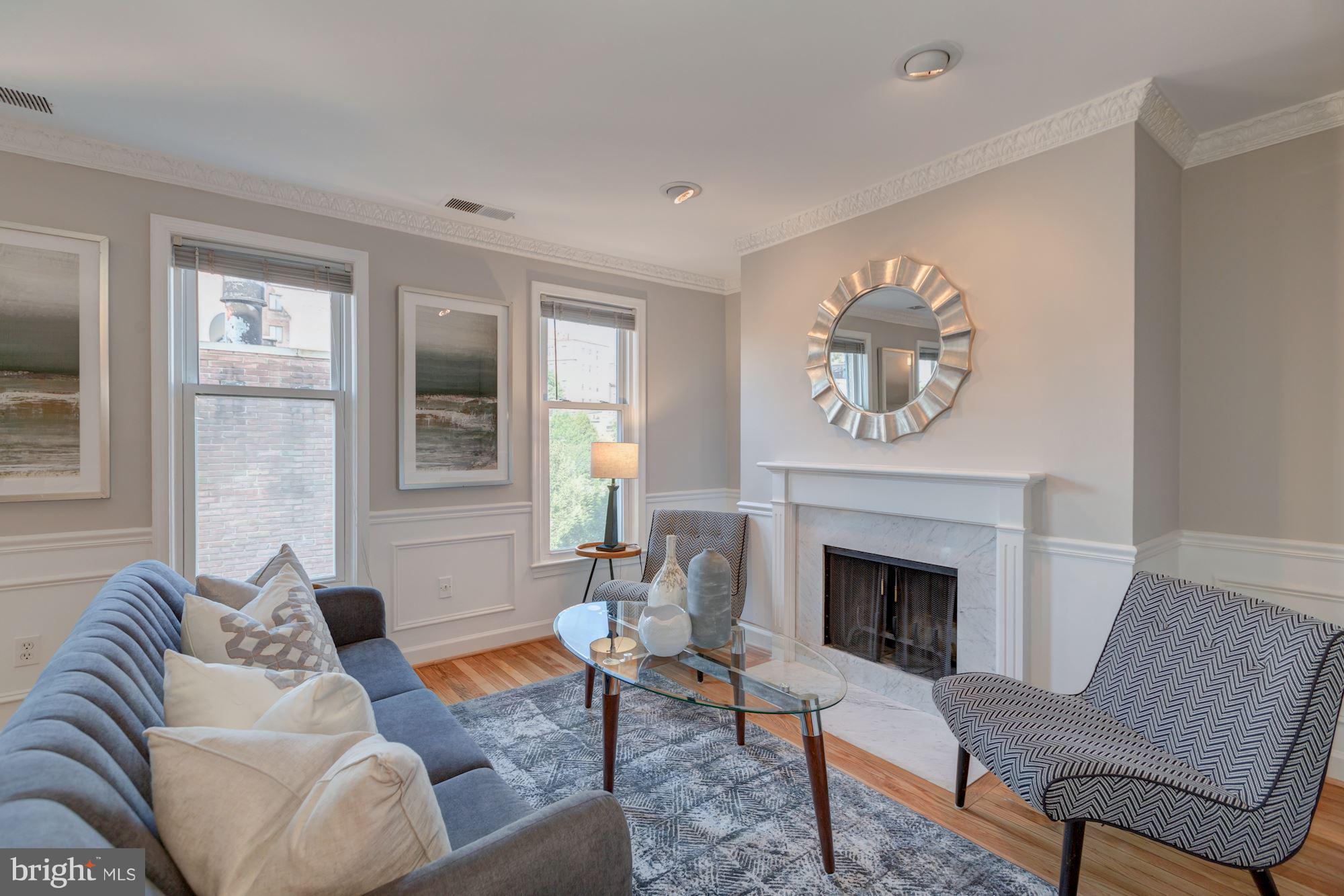 a living room with furniture a fireplace and a window