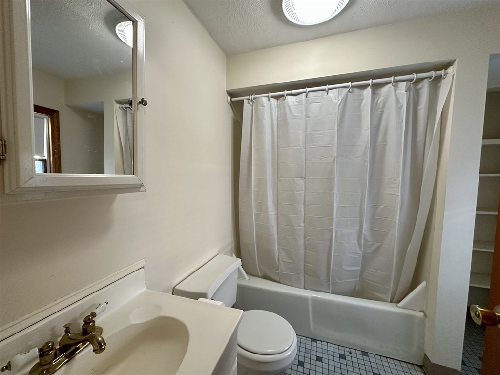 5 Rifle Court, Unit 5 Watertown, MA 02472 - Photo 5 of 14 a white toilet sitting next to a bathroom sink