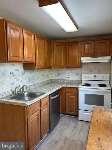 a kitchen with a sink stove and cabinets