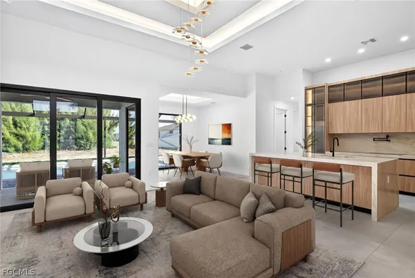 an empty room with chandelier fan and windows