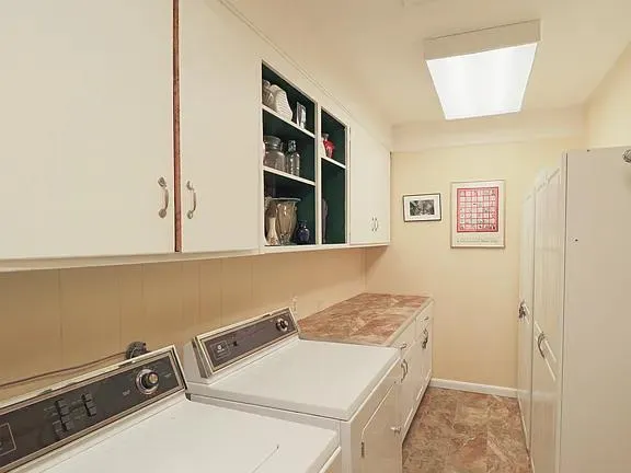 a utility room with a refrigerator and a window