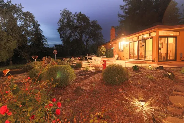 a backyard of a house with table and chairs and potted plants