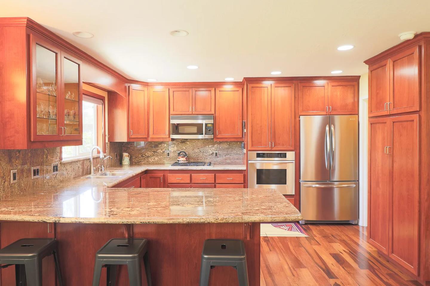 6600 Guerneville Road Sebastopol, CA 95472 - Photo 9 of 13 a kitchen with stainless steel appliances granite countertop a refrigerator a sink dishwasher and wooden cabinets with wooden floor