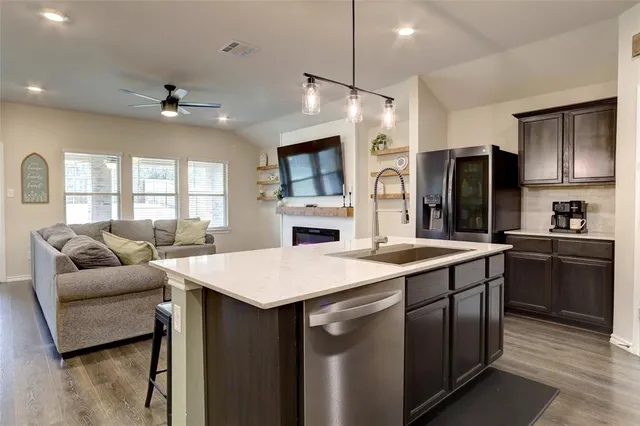 a kitchen with kitchen island a sink stove and refrigerator