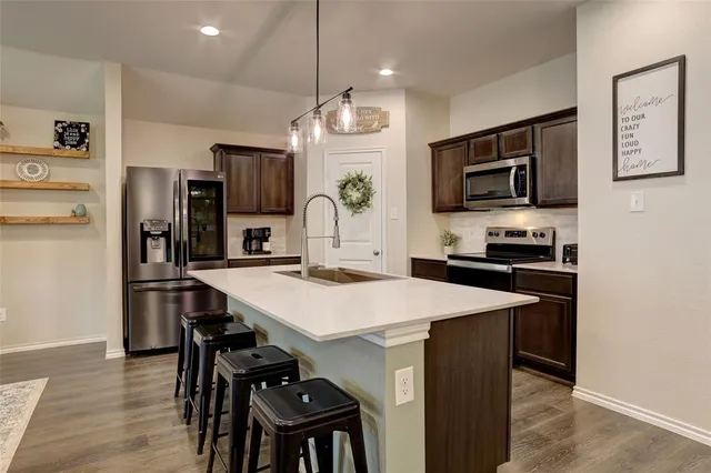 a kitchen with stainless steel appliances a stove a microwave and sink