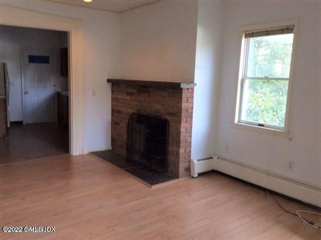83 William Street, Unit 1 Greenwich, CT 06830 - Photo 7 of 10 an empty room with windows and fireplace