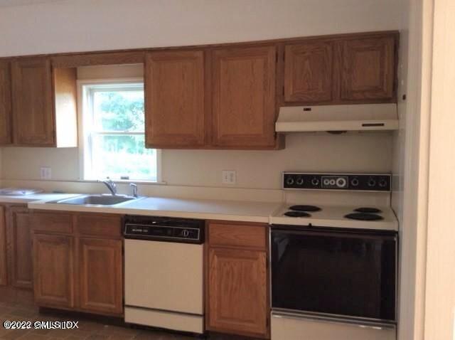 83 William Street, Unit 1 Greenwich, CT 06830 - Photo 9 of 10 a kitchen with granite countertop wooden cabinets and a stove top oven