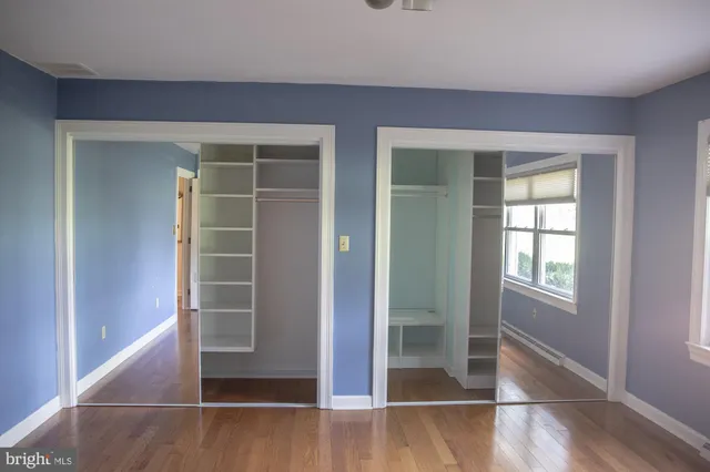 an empty room with a window and a chair