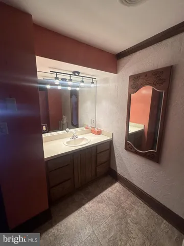 a spacious bathroom with a granite countertop sink a mirror and a shower