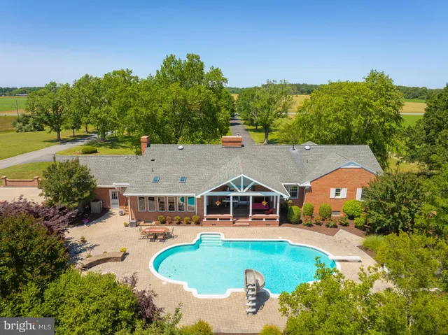 a view of a hallway with wooden floor and a living room
