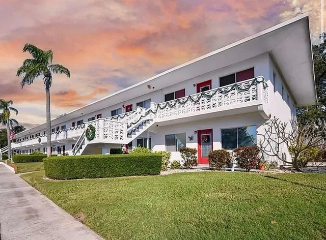 a view of a house with a big yard and potted plants