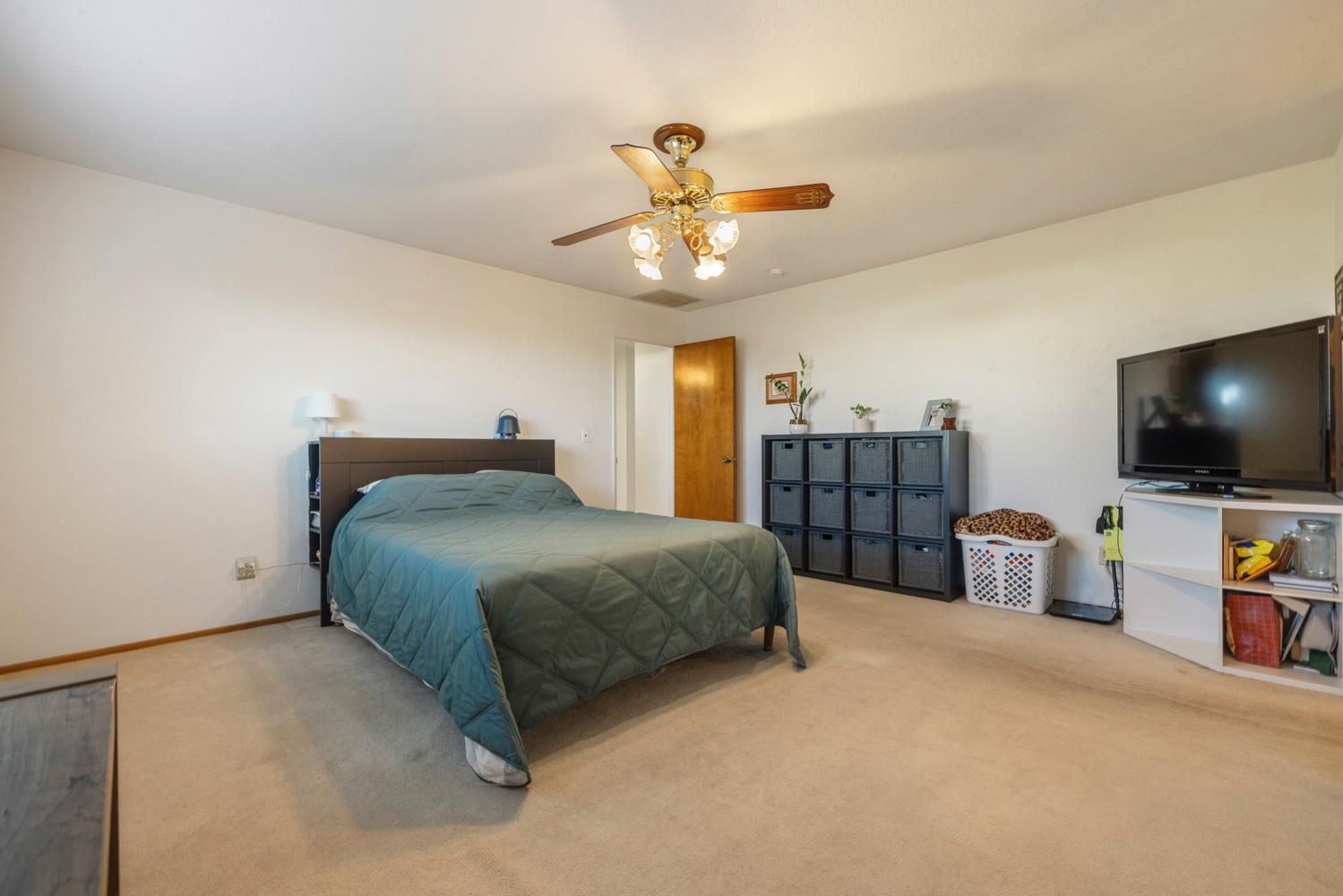 24836 Arthur Road Escalon, CA 95320 - Photo 19 of 47 a bedroom with a bed and a chandelier