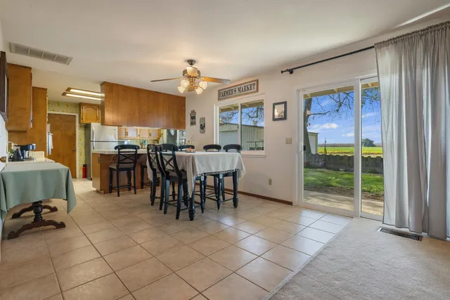 a kitchen with stainless steel appliances a table chairs and a refrigerator