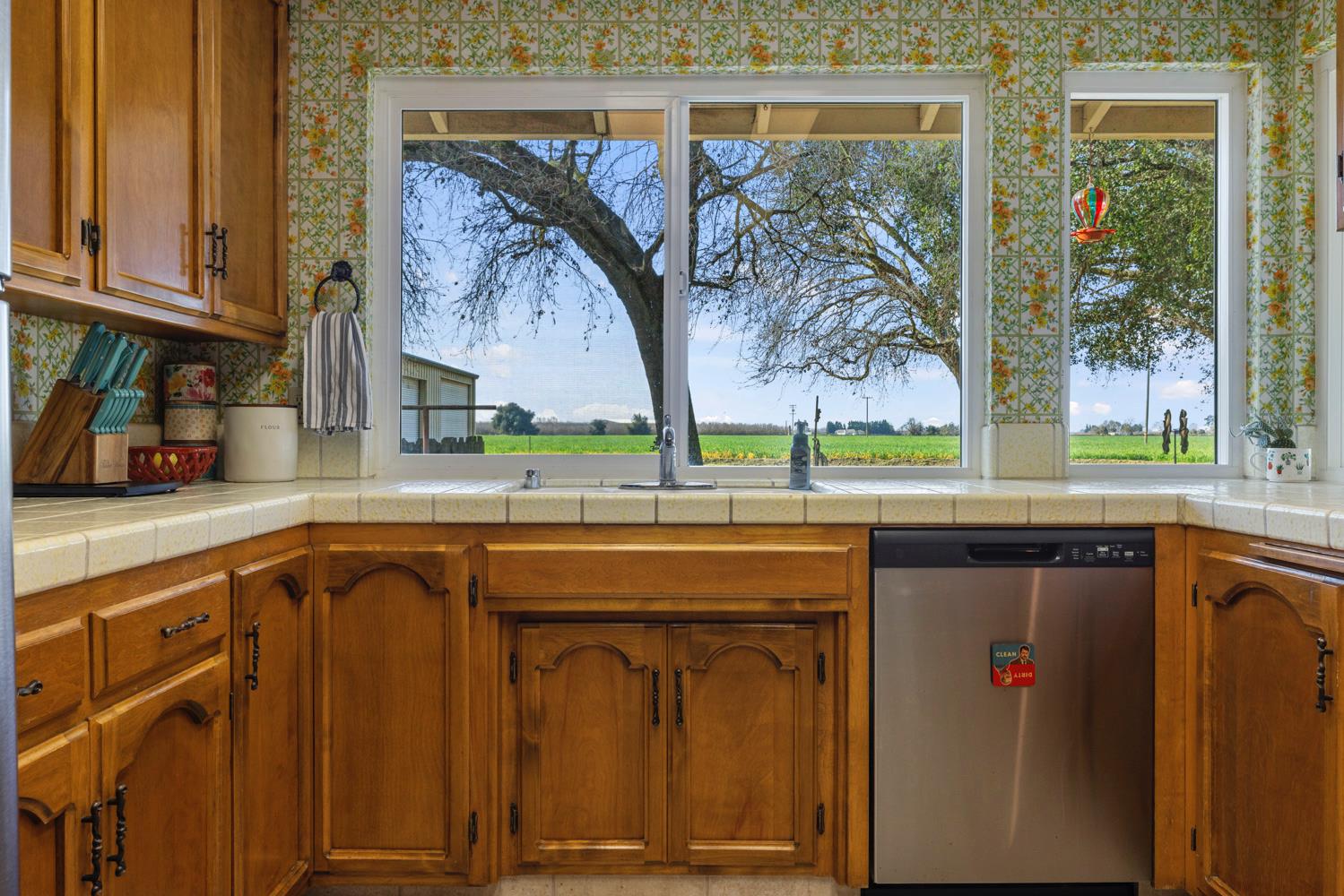 24836 Arthur Road Escalon, CA 95320 - Photo 30 of 47 a utility room with stainless steel appliances granite countertop a stove a sink and dishwasher with wooden cabinets