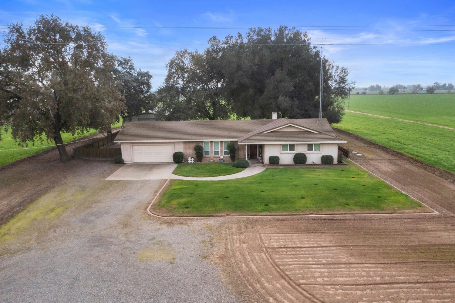 24836 Arthur Road Escalon, CA 95320 - Photo 44 of 47 a view of a white house with a big yard plants and large trees