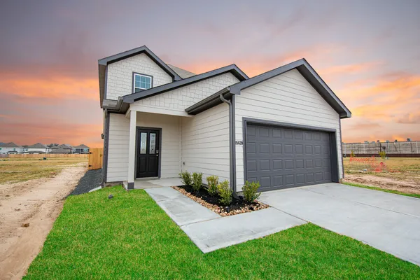 a front view of house with a garden and yard