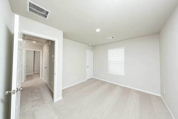 an empty room with a windows and closet