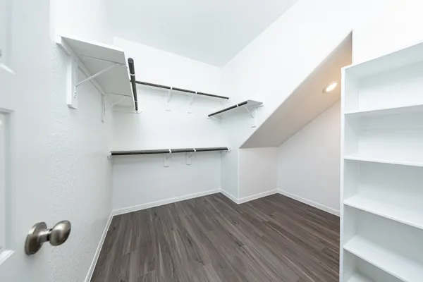 a view of walk in closet with empty racks