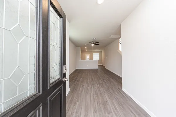a view of a hallway with wooden floor and staircase