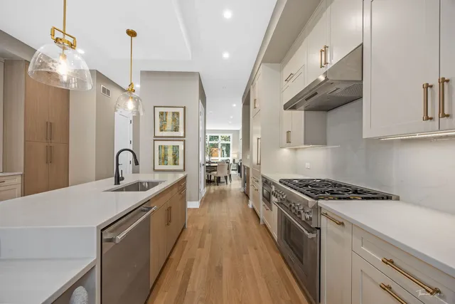 a kitchen with stainless steel appliances a sink stove and cabinets