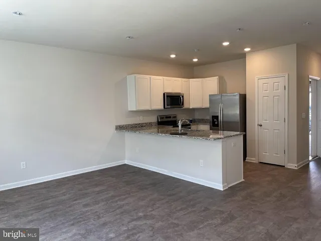 a open kitchen with white cabinets and stainless steel appliances