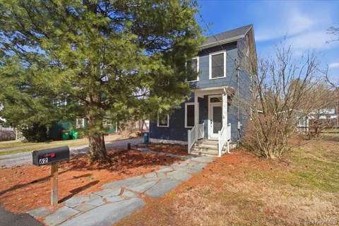 a front view of a house with a tree
