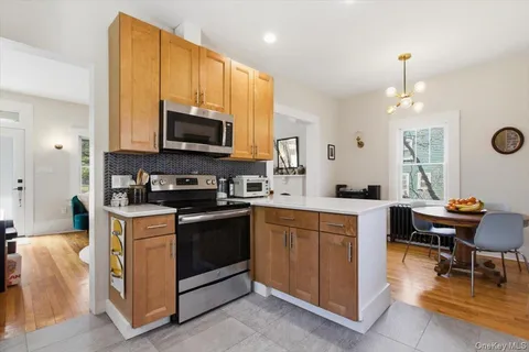 a kitchen with a stove top oven a sink a dining table and chairs