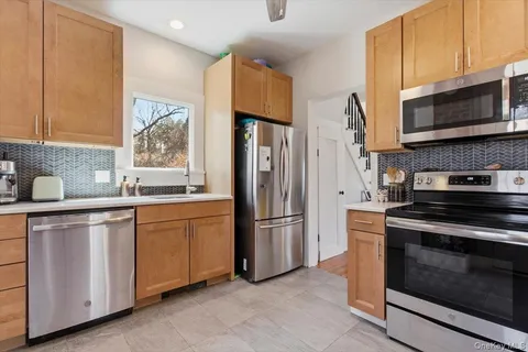 a kitchen with stainless steel appliances granite countertop a stove a refrigerator and a microwave
