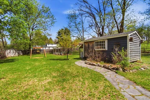 a view of a house with backyard and sitting area
