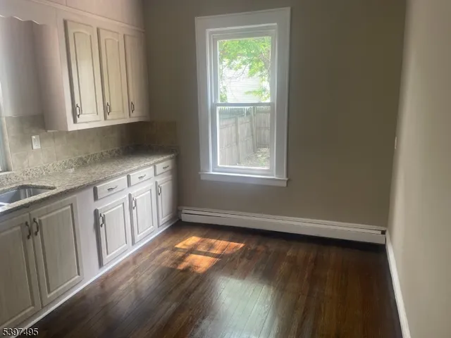 a view of a kitchen with wooden floor and cabinets