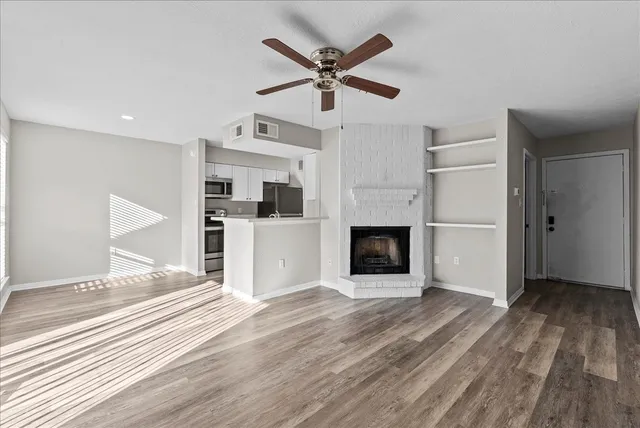 a view of a livingroom with wooden floor and a ceiling fan
