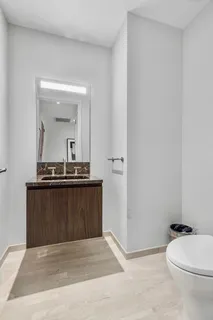 a bathroom with a sink a toilet a mirror and vanity