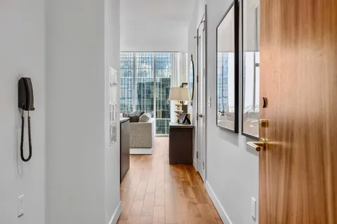 a view of a hallway with wooden floor and dining room